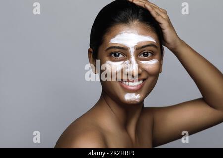 Jeune femme indienne avec un masque de nettoyage appliqué sur son visage Banque D'Images