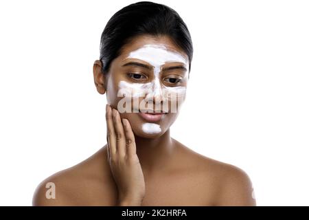 Jeune femme indienne avec un masque de nettoyage appliqué sur son visage Banque D'Images