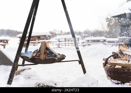 Bois de chauffage brûlant à l'intérieur de la fosse à feu pendant la journée froide d'hiver Banque D'Images