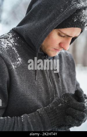 Beau sportif portant un sweat à capuche pendant son entraînement d'hiver Banque D'Images