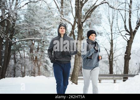 Couple sportif pendant le jogging d'hiver dans le parc de la ville Banque D'Images