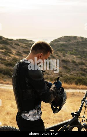 Descente de pilote entièrement équipée avec équipement de protection et son vélo Banque D'Images