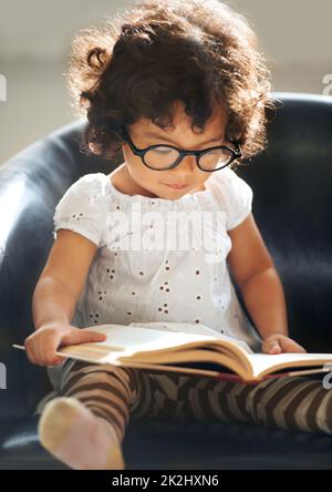 Apprendre au fur et à mesure de sa croissance.Photo d'une petite fille mignonne à la maison. Banque D'Images