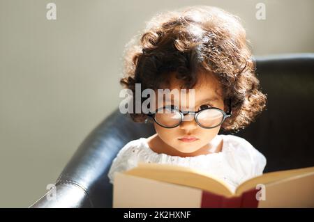 Apprendre au fur et à mesure de sa croissance.Photo d'une petite fille mignonne à la maison. Banque D'Images