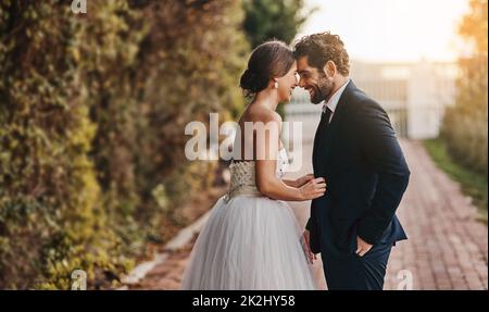 Vous êtes ma femme maintenant.Photo d'un jeune couple heureux debout ensemble le jour de leur mariage Banque D'Images