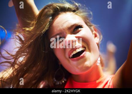 Sensation de vibe. Vue rognée d'une jeune femme dansant dans un club - ce concept a été créé dans le seul but de cette séance photo, avec 300 modèles et 3 groupes live. Tous les participants à cette séance photo sont sortis du modèle. Banque D'Images