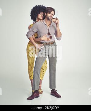 Couple rétro.Un jeune couple attrayant debout ensemble dans des vêtements rétro 70s. Banque D'Images