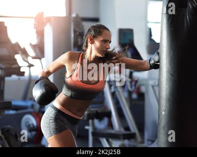 Élégance sustpaw.Photo d'un boxeur féminin s'entraîner sur un sac de poinçonnage dans la salle de sport. Banque D'Images