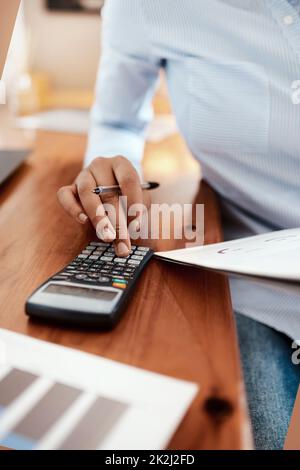 Laissez les chiffres parler. Photo rognée d'une femme d'affaires utilisant une calculatrice tout en passant par les documents financiers à son bureau. Banque D'Images