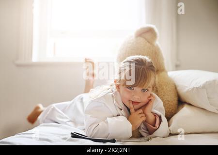 Le médecin est prêt pour vous. Photo d'une adorable petite fille vêtue comme médecin et traitant son ours en peluche comme une patiente. Banque D'Images