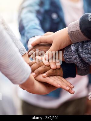 Des amis se collent. Photo d'un groupe d'enfants d'école élémentaire méconnus qui se joignent aux mains lors d'un caucus. Banque D'Images