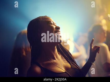 Une jeune fille faisant la fête dans un club et se déplaçant à la musique. Ce concert a été créé dans le seul but de cette séance photo, avec 300 modèles et 3 groupes live. Tous les participants à cette séance photo sont sortis du modèle. Banque D'Images