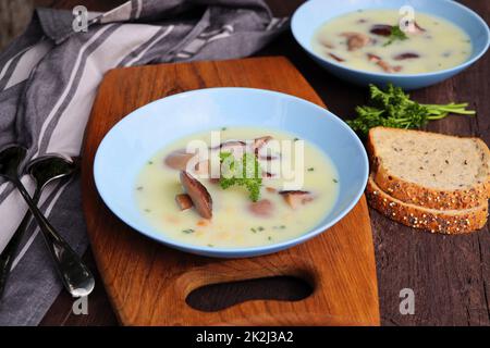 Soupe crémeuse aux champignons et aux herbes sur une table en bois Banque D'Images