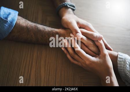 Vous améliorez ma vie en y étant. Plan court d'un homme et d'une femme tenant les mains à une table avec compassion. Banque D'Images