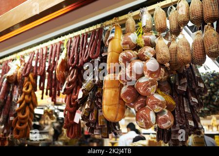 Marché pour les amateurs de viande. Saucisses séchées et salami accrochées à des crochets dans un marché. Banque D'Images