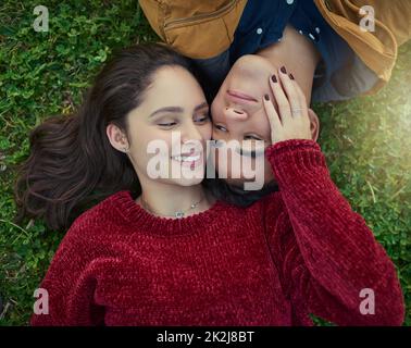 Avec vous à côté de moi, la vie est complète. Photo en grand angle d'un jeune couple heureux qui repose sur l'herbe. Banque D'Images