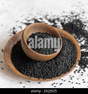 Épices indiennes graines de cumin noir (nigella sativa ou kalonji) dans des bols en bois gros plan Banque D'Images