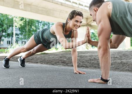 Couple sportif et entraînement physique en plein air. Homme et femme faisant de l'exercice push-up. Banque D'Images