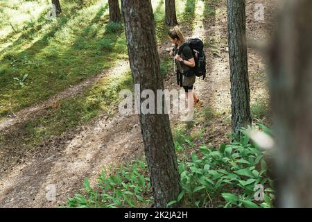 Randonneur féminin avec grand sac à dos dans la forêt verte Banque D'Images