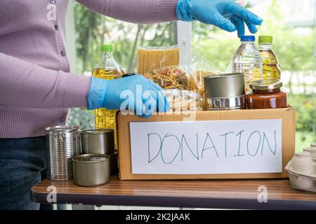 Produits alimentaires pour le don, l'entreposage et la livraison. Divers aliments, pâtes, huile de cuisson et conserves dans une boîte en carton. Banque D'Images