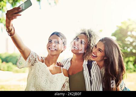 L'ID des médias sociaux va adorer ça. Prise de vue d'un groupe d'amis prenant un selfie en plein air. Banque D'Images