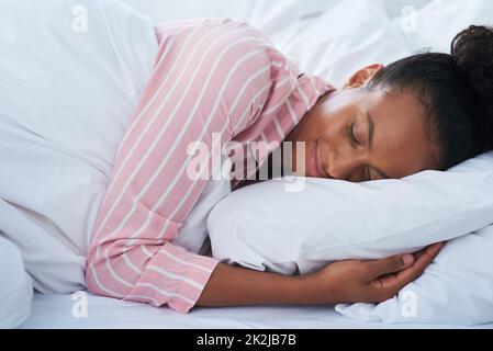 Dormir comme un bébé. Photo d'une jeune femme attrayante dormant paisiblement au lit à la maison. Banque D'Images