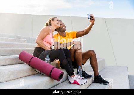 Entraînement de couple sportif interracial à l'extérieur - couple multiracial portant des vêtements de sport et faisant de l'entraînement fonctionnel à l'extérieur pour les muscles tendus du corps, Banque D'Images