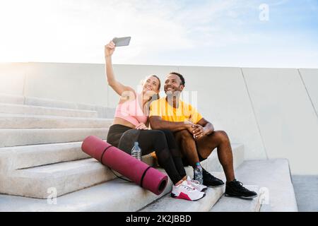 Entraînement de couple sportif interracial à l'extérieur - couple multiracial portant des vêtements de sport et faisant de l'entraînement fonctionnel à l'extérieur pour les muscles tendus du corps, Banque D'Images