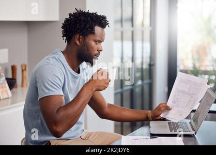 Ils regardent la cause des mouvements que je fais leur budget. Photo d'un homme qui a traversé des documents et qui a l'air inquiet à la maison tout en prenant un café. Banque D'Images