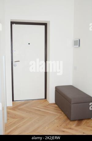 Porte d'entrée de maison moderne en métal, couloir intérieur avec système de maison intelligente. Banque D'Images