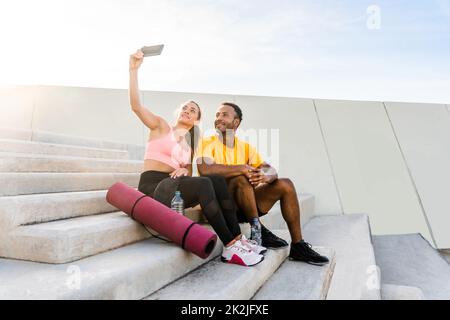 Entraînement de couple sportif interracial à l'extérieur - couple multiracial portant des vêtements de sport et faisant de l'entraînement fonctionnel à l'extérieur pour les muscles tendus du corps, Banque D'Images