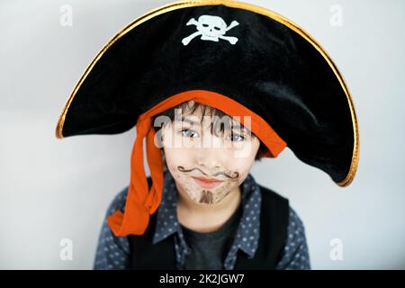 Im le capitaine de ce navire. Photo d'un petit garçon portant un costume de pirate sur fond blanc. Banque D'Images