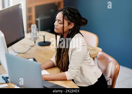 Travailler dur pour faire sortir son entreprise du sol. Prise de vue en grand angle d'une jeune femme attrayante travaillant sur un ordinateur dans son bureau à domicile. Banque D'Images