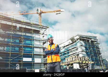 Vous pouvez compter sur notre qualité de construction. Portrait d'un jeune homme confiant travaillant sur un chantier de construction. Banque D'Images