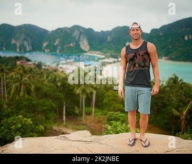 Passons au mode tropical. Portrait d'un jeune homme heureux posant devant un paysage insulaire. Banque D'Images