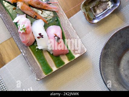 Le sushi est magnifiquement disposé sur une plaque en céramique. Buffet de cuisine japonaise. Choix du chef : crevettes, thon, Nodoguro et KINKI Banque D'Images