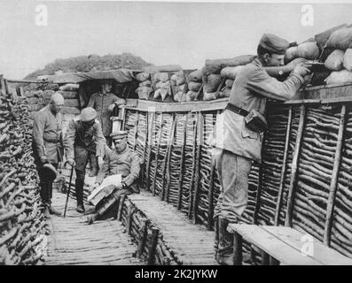 Première Guerre mondiale 1914-1918: Vue à l'intérieur des tranchées allemandes en France, 1915. Les agents examinent les plans tandis qu'un rifleman garde la surveillance derrière les sacs de sable. Banque D'Images