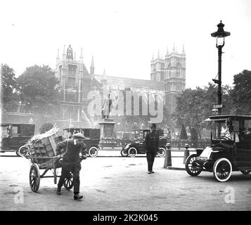 Scène de rue, Westminster, Londres, avec des voitures, garçon avec charrette, et policier en service, c 1910. Photographie. Banque D'Images