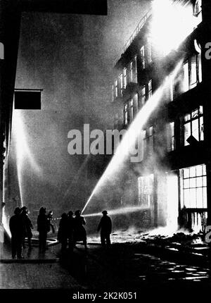 La Deuxième Guerre mondiale, 1939-1945. Pompiers lutter contre un entrepôt de la ville après un raid aérien allemand pendant la blitz sur Londres, 1940. Banque D'Images