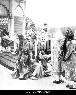 George V, Roi de Grande-Bretagne 1910-1936, avec son épouse la reine Mary, regardant Delhi Durbar du Fort Rouge, accompagné par le princes indiens agissant comme pages. L'Inde, 1911. Banque D'Images