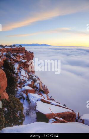 Lever de soleil en hiver à Grandview point avec une mer de nuages en dessous. Parc national des Canyonlands. Les montagnes de la Sal derrière. Banque D'Images