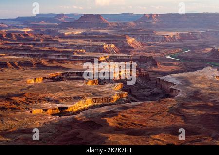 Coucher de soleil sur les falaises de grès de White Rim dans le bassin de Green River dans le parc national de Canyonlands, Utah. Ekker Butte et les falaises Orange sont à la tête Banque D'Images