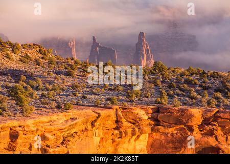 Sunrise and low clouds on the mesa of the Island in the Sky District of Canyonlands National Park, Moab, Utah.  Viewed from the Buck Canyon Overlook. Stock Photo