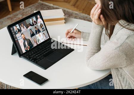 E-learning web chat. Distance education. Professional webinar. Female student watching business coach presentation with group on laptop screen in digi Stock Photo