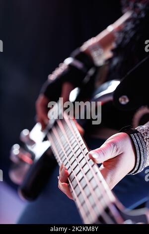 Une musicienne jouant de la guitare électrique pendant un spectacle Banque D'Images