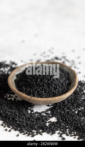 Épices indiennes graines de cumin noir (nigella sativa ou kalonji) dans un bol en gros plan Banque D'Images