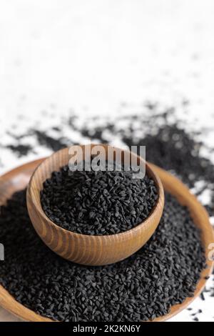 Épices indiennes graines de cumin noir (nigella sativa ou kalonji) dans des bols en bois gros plan Banque D'Images