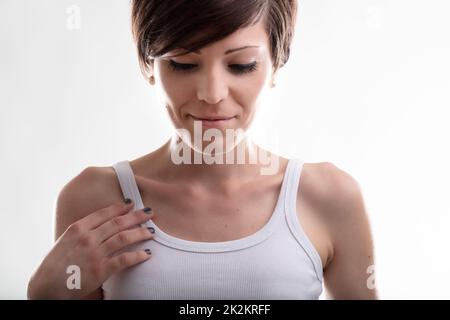 Demure jeune femme avec sa main à sa poitrine Banque D'Images