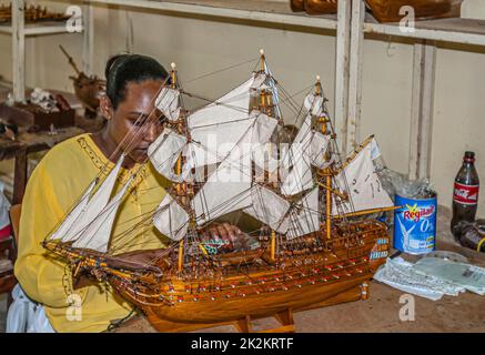 Ouvrier à un atelier de fabrication de bateau-maquette souvenir à Port Louis, Maurice Banque D'Images