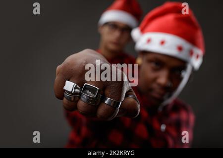 Jeune Noir portant un chapeau et des anneaux du Père Noël Banque D'Images